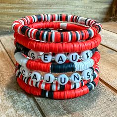 "Red, Black, and White Bracelet Stack - Perfect to pair with your game day attire! Mix and Match! Wear one or wear them all together! Geaux Cajuns!       Please Note:    When putting the bracelet on please \"roll\" it on. Stretching out the bracelet can cause it to change size over time.       Bracelets are 7\" in length. If a different size is needed please let me know." Cheap White Beaded Bracelets For Game Day, Red Smiley Face Clay Bracelet, Red Team Spirit Bracelets For Gifts, Game Day Black Wristband With Letter Beads, Red Personalized Bracelets For Team Spirit, Red Personalized Bracelets With Team Spirit Style, Personalized Red Bracelets For Team Spirit, Personalized Red Stretch Bracelet, Casual Style, Red Beaded Bracelets With Letter Beads For Game Day