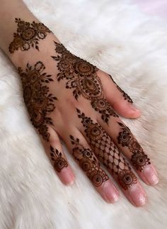 a woman's hand with henna tattoos on it