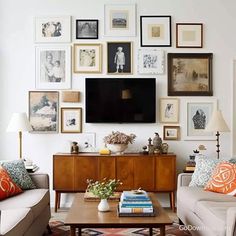 a living room filled with furniture and lots of pictures on the wall above it is a flat screen tv