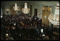 a large room full of people and chandeliers in the middle of it,