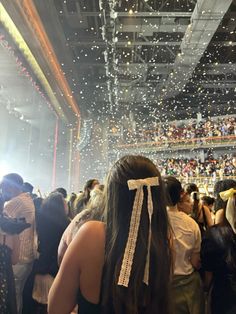 the back of a woman's head in front of a crowd at a concert