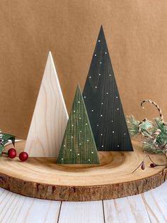 three wooden christmas trees sitting on top of a table