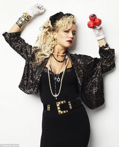 a woman in a black dress holding a red pepper on her head with both hands