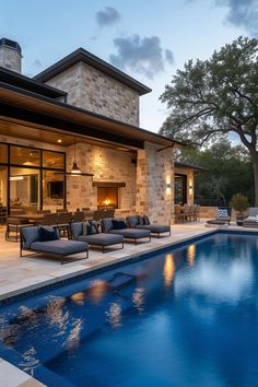 an outdoor living area next to a swimming pool with chaise lounges on it