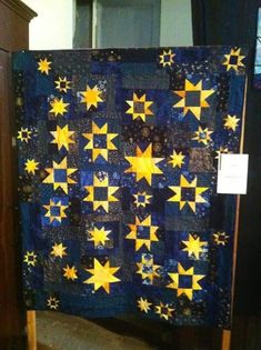 a blue and yellow quilt with stars on it