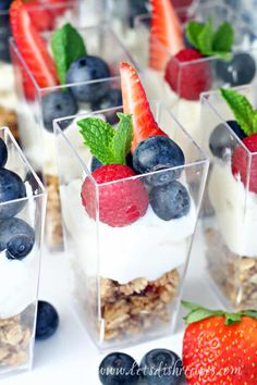 fruit and yogurt parfait desserts are arranged in small glass containers