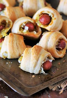 several hot dogs wrapped in crescent pastry on a baking sheet, ready to be eaten