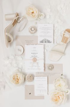 the wedding stationery is laid out with white flowers