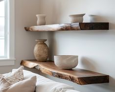 some shelves with bowls and vases on them in a living room or dining room