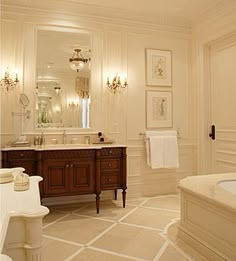 a bathroom with a tub, sink, and mirror in the middle of it's walls