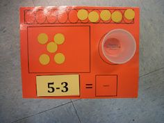 an orange board with yellow dots on it and a cup next to it that says 5 - 3