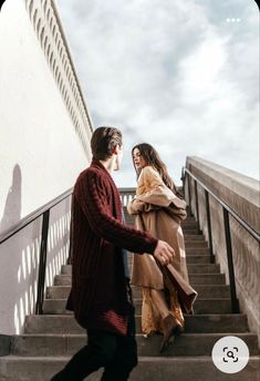 two people are walking up some stairs and one person is holding onto the handrail