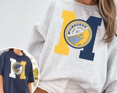 WELCOME TO MY STORE ♥️ _This Vintage Milwaukee Brewer Crewneck Sweatshirt / T-Shirt, Brewers EST 1970 Sweatshirt, Milwaukee Baseball Game Day Shirt, Retro Brewers Shirt, Retro Milwaukee, Milwaukee Sweater, Brewers Sweater, Brewers Sweatshirt, Milwaukee Game Day, Brewers Fan Gift, Vintage Baseball Tee, Gift for her, Gift for Mom, Gift for him, Baseball Season, World Series, Game Day Shirt. _Please check Color and Size Charts before placing the order. You can find them in the listing's photos (Dep School Spirit Crew Neck T-shirt With Letter Print, School Spirit T-shirt With Letter Print And Crew Neck, School Spirit T-shirt With Letter Print, School Spirit Crew T-shirt With Team Name, School Spirit Crew Neck T-shirt With Team Name, Fan Apparel Short Sleeve Graphic Sweatshirt, Relaxed Fit Short Sleeve Fan Apparel Sweatshirt, Short-sleeve Cotton Sweatshirt For College, Baseball Vintage