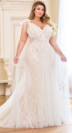 a woman in a wedding dress posing for the camera with her hands on her hips