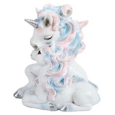 a white and blue unicorn figurine sitting on the ground