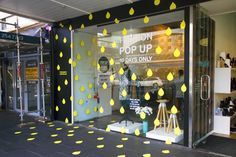 a storefront with yellow raindrops on the windows