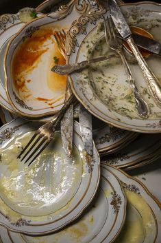 a pile of dirty plates with silverware on them