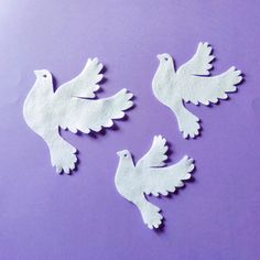 three white doves on a purple background