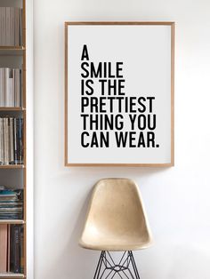 a poster hanging on the wall above a chair in front of a bookshelf