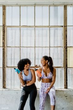 two women sitting next to each other drinking