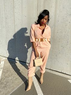 This peach jumpsuit is one of those quintessential vintage pieces. It has a cinched waist, button closures, and structured shoulders. Pair this jumpsuit with your favorite tan accessories for a fun neutral color palette.  * Size M-L * Peach color * Button closures * Structured shoulders Mila & Fire is an online store full of contemporary, vintage, & reconstructed threads that exude an energy of individualism and style. Chic Beige Belted Jumpsuit, Vintage Summer Jumpsuits And Rompers For Work, Chic Beige Jumpsuits And Rompers For Day Out, Vintage Jumpsuits And Rompers For Summer Workwear, Pink Retro Jumpsuits And Rompers For Spring, Chic Orange Fitted Jumpsuits And Rompers, Orange Fitted Chic Jumpsuits And Rompers, Retro Summer Jumpsuits And Rompers For Work, Chic Beige Jumpsuits And Rompers For Work