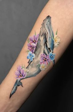 a woman's arm with a horse and flowers on it