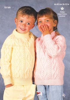 two young children in sweaters and pants posing for the camera with their hands on their faces