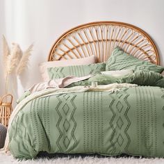 a bed with green comforter and pillows in a room next to a wicker headboard