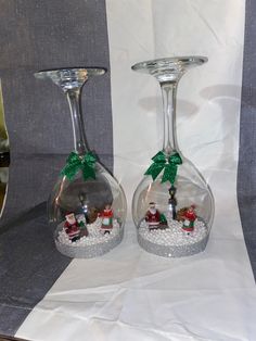 two wine glasses with christmas decorations in them