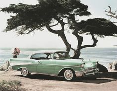 an old green car parked on the beach