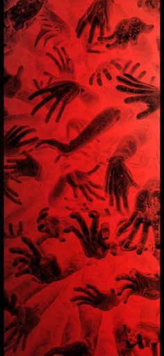 an image of many hand prints on red paper