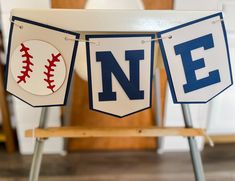 two baseball banners with the letters n e hanging on a chair in front of a table