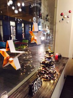 a christmas tree made out of paper stars on display in a store window with other decorations