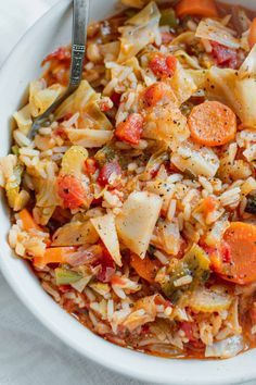 a bowl filled with rice, carrots and other vegetables on top of a table