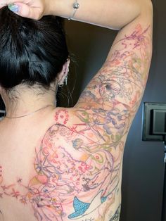 a woman with tattoos on her back and arm