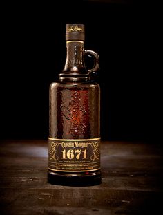 an old fashioned glass bottle sitting on top of a wooden table next to a black background