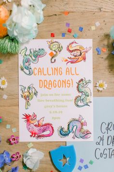 a birthday party with confetti and paper decorations on the table, including a card that says calling all dragon