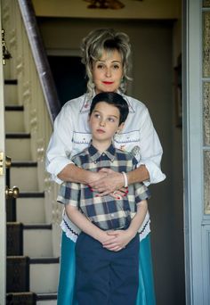 a woman standing next to a young boy