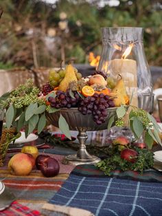 the table is set with fruit and candles