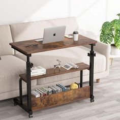 a laptop computer sitting on top of a wooden table next to a white couch in a living room