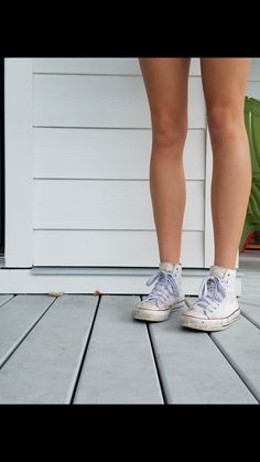 a person with white shoes standing on a porch