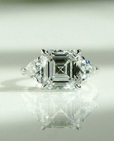 an emerald cut diamond with three diamonds on the side