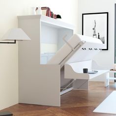 an open book shelf in the middle of a living room with a lamp on it