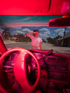 the inside of a car with a red dash light and steering wheel in front of it