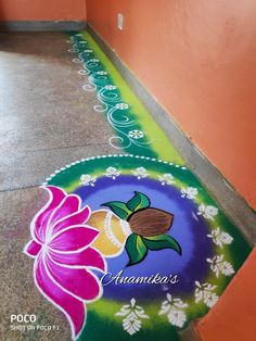 a colorfully painted floor with flowers and leaves on the ground in front of an orange wall