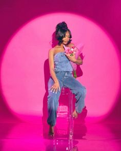 a woman sitting on top of a pink chair