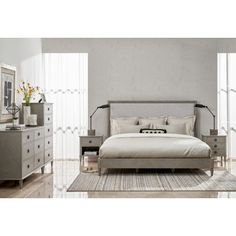 a bedroom with a bed, dressers and mirror in it's center area