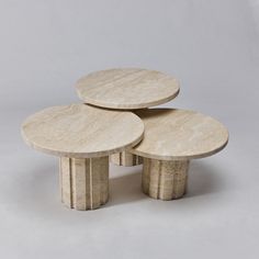 three round marble tables stacked on top of each other in the shape of four circles