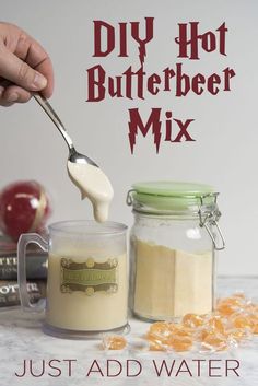 a hand holding a spoon over a jar filled with liquid