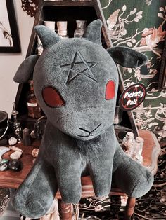 a gray stuffed animal sitting on top of a wooden chair